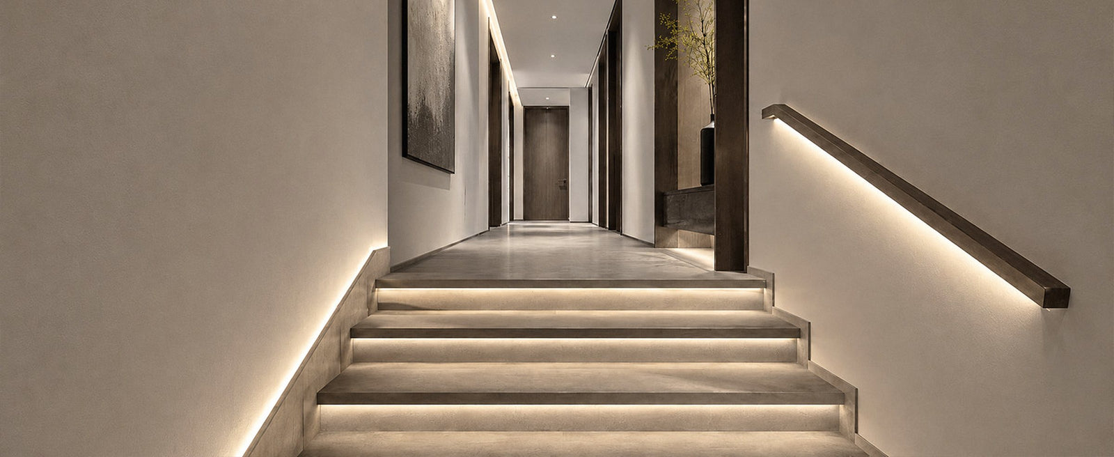 A hallway and stair at night: a strip under each tread, along the skirting and under the handrail